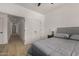 Comfortable bedroom with hardwood floors, gray headboard, nightstand, and white door to the hall at 8156 E Questa Rd, Scottsdale, AZ 85255