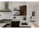 Modern kitchen boasts stainless steel appliances, white countertops, dark wood cabinets, and stainless range hood at 8156 E Questa Rd, Scottsdale, AZ 85255