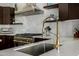 A modern kitchen offering tile backsplash, gold faucet, and stainless gas range at 8156 E Questa Rd, Scottsdale, AZ 85255