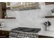 Close up shot showcasing the stainless hood, tile backsplash, and gas range at 8156 E Questa Rd, Scottsdale, AZ 85255