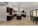 Bright modern kitchen boasts an island, stainless steel appliances, dark wooden cabinetry, and hardwood floors at 8156 E Questa Rd, Scottsdale, AZ 85255
