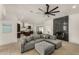 Spacious living room featuring a gray sectional, black granite fireplace, hardwood floors and an open kitchen layout at 8156 E Questa Rd, Scottsdale, AZ 85255