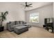 Comfortable living area featuring wood flooring, a gray sofa, a ceiling fan, and exterior view through an arched window at 8156 E Questa Rd, Scottsdale, AZ 85255