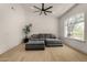 Bright living room features a large gray couch, hardwood floors, and abundant natural light through a large window at 8156 E Questa Rd, Scottsdale, AZ 85255