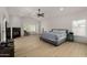 Spacious main bedroom featuring a ceiling fan, fireplace, light floors, and large windows for ample natural light at 8156 E Questa Rd, Scottsdale, AZ 85255