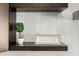 Close up of a decorative shelf with white tiled walls, dark wood shelf, and 'relax & renew' sign at 8156 E Questa Rd, Scottsdale, AZ 85255