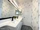 A bathroom featuring a large double vanity with black faucets and floral-patterned wallpaper at 854 W Mesquite St, Gilbert, AZ 85233