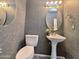 Stylish half bathroom featuring elegant pedestal sink, toilet, and decorative mirror at 854 W Mesquite St, Gilbert, AZ 85233