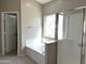 Bright bathroom featuring a glass door shower, a soaking tub with a decorative window, and a white panel door at 854 W Mesquite St, Gilbert, AZ 85233