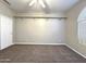 Neutral-toned bedroom featuring carpet, a ceiling fan, and a built-in shelf with wall-mounted brackets at 854 W Mesquite St, Gilbert, AZ 85233