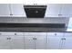 Close-up of a modern kitchen countertop with white cabinets, a black backsplash, and sleek appliances at 854 W Mesquite St, Gilbert, AZ 85233