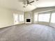 Neutral-toned living room with carpet, a fireplace, and a glass door to a patio at 854 W Mesquite St, Gilbert, AZ 85233