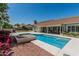 Backyard featuring a sparkling pool, hot tub, covered patio, manicured landscaping, and outdoor entertaining space at 921 N Oxford Ln, Chandler, AZ 85225