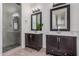 Bright bathroom featuring double vanity, dark wood cabinets, and glass shower with pebble floor at 921 N Oxford Ln, Chandler, AZ 85225