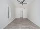 Empty bedroom features wood-look tile flooring, a modern ceiling fan, and abundant natural light from the windows at 921 N Oxford Ln, Chandler, AZ 85225