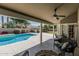 Cozy covered patio with ceiling fan, wicker furniture, and a view of the pool and landscaped backyard at 921 N Oxford Ln, Chandler, AZ 85225