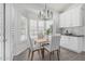 A charming dining nook features white cabinets, modern chandelier, and shuttered windows with lots of natural light at 921 N Oxford Ln, Chandler, AZ 85225
