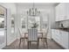Bright dining area with wood-look tile floors, white cabinets, and a view of the backyard pool through shuttered windows at 921 N Oxford Ln, Chandler, AZ 85225