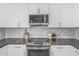 Modern kitchen features stainless steel appliances, granite countertops, and bright white cabinets at 921 N Oxford Ln, Chandler, AZ 85225