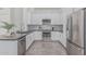 Modern kitchen with white cabinets, stainless steel appliances, granite countertops, and stylish tile backsplash at 921 N Oxford Ln, Chandler, AZ 85225