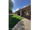 Large backyard featuring well-manicured artificial grass, a covered patio, and desert landscaping at 9733 W Mcrae Way, Peoria, AZ 85382