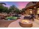 Resort style backyard features a pool, spa, patio, dining area, fire pit, BBQ, and lush desert landscaping at 9913 E Quarry Trl, Scottsdale, AZ 85262