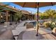 Lush backyard with swimming pool and rock waterfall with multiple seating areas for entertaining guests at 9913 E Quarry Trl, Scottsdale, AZ 85262