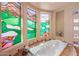 Bright bathroom boasting a jetted tub surrounded by decorative stained glass windows at 9913 E Quarry Trl, Scottsdale, AZ 85262