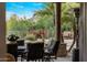 Inviting covered patio with an elegant outdoor dining table with views of lush landscaping at 9913 E Quarry Trl, Scottsdale, AZ 85262