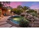 Backyard pool with a rock waterfall, cacti, and lush mature landscaping at 9913 E Quarry Trl, Scottsdale, AZ 85262