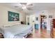 Bedroom with a ceiling fan, laminate floors, and adjoining bathroom and closet at 10330 W Thunderbird Blvd # A209, Sun City, AZ 85351