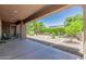 Inviting covered back patio overlooking a well-maintained landscaped backyard with mature trees and plants at 13052 W Mine Trl, Peoria, AZ 85383