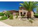 Lush desert landscaping complements this lovely home with a front facing two car garage and an arched front door at 13052 W Mine Trl, Peoria, AZ 85383