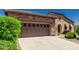Two car garage with desert landscaping, a walkway and a stone facade to the left of the front door at 13052 W Mine Trl, Peoria, AZ 85383