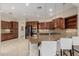 Gourmet kitchen with granite countertops, dark wood cabinetry, and stainless steel appliances at 13052 W Mine Trl, Peoria, AZ 85383