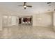 Bright open floor plan with neutral tile, ceiling fan, and views to the kitchen and dining area at 13052 W Mine Trl, Peoria, AZ 85383