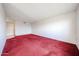 Spacious living room featuring red carpeting and tile flooring, providing a blank canvas for decor at 13618 N 98Th Ave # C, Sun City, AZ 85351