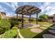 Backyard oasis showcasing lush landscaping, hardscape, and a pergola-covered patio perfect for entertaining at 14674 W Pasadena Ave, Litchfield Park, AZ 85340