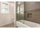 Bright bathroom featuring a tub with glass doors and an alcove shelf for optimal storage and display at 14674 W Pasadena Ave, Litchfield Park, AZ 85340