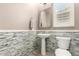 Stylish powder room featuring decorative mosaic tile accents and a pedestal sink at 14674 W Pasadena Ave, Litchfield Park, AZ 85340