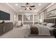 Staged primary bedroom showcasing an accent wall, tray ceiling, and neutral decor at 14674 W Pasadena Ave, Litchfield Park, AZ 85340