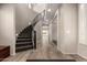 Elegant foyer with a curved staircase, tile flooring, and modern lighting for a grand entrance at 14674 W Pasadena Ave, Litchfield Park, AZ 85340