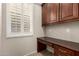 Office with a dark wood desk, window with shutter, and storage space for supplies and equipment at 14674 W Pasadena Ave, Litchfield Park, AZ 85340