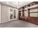 Office area featuring custom built-in cabinetry and doors to the outdoor living area at 14674 W Pasadena Ave, Litchfield Park, AZ 85340