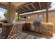 The outdoor kitchen boasts stainless steel grill and countertop space beneath a shaded pergola, perfect for barbecues at 14674 W Pasadena Ave, Litchfield Park, AZ 85340