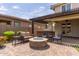 Cozy outdoor seating area with a stone fire pit and an outdoor kitchen offers comfortable outdoor living at 14674 W Pasadena Ave, Litchfield Park, AZ 85340