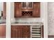Stylish wet bar with custom cabinets, granite countertop and stainless steel wine refrigerator at 14674 W Pasadena Ave, Litchfield Park, AZ 85340