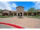 Grand clubhouse entrance featuring stone facade, arched entryway, and desert landscaping for a welcoming arrival at 1641 N Channing --, Mesa, AZ 85207