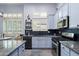 Modern kitchen with stainless steel appliances, stylish countertops, blue cabinets, and a black backsplash at 1641 N Channing --, Mesa, AZ 85207