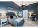 Well-lit main bedroom with dark blue accent wall, cozy decor, ceiling fan, and a view of a desk nook at 1641 N Channing --, Mesa, AZ 85207